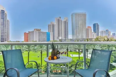 two chairs and a table on a balcony with a city at Center of Joy in Sunny Isles Beach