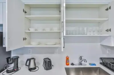 a kitchen with white cabinets and a sink at Center of Joy in Sunny Isles Beach
