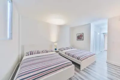 two beds in a room with white walls at Center of Joy in Sunny Isles Beach
