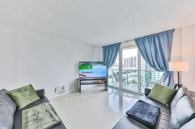 a living room with a couch and a flat screen tv at The Elevated Above STR-02687 in Sunny Isles Beach