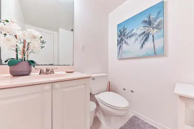 a white bathroom with a toilet and a sink at The Elevated Above STR-02687 in Sunny Isles Beach