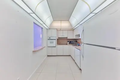 a kitchen with white cabinets and a ceiling at The Elevated Above STR-02687 in Sunny Isles Beach