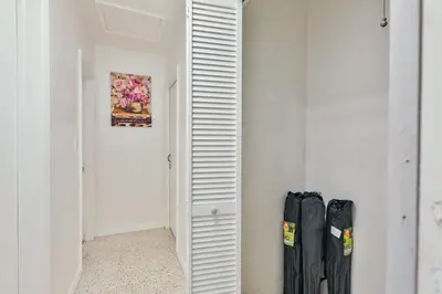 a hallway with white walls and a closet with black doors at Quiet family vacation minutes from Airport in Fort Lauderdale