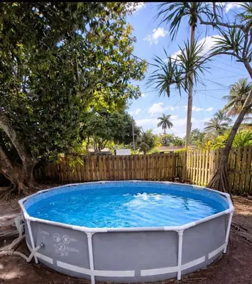 a hot tub in a backyard with a fence at Quiet family vacation minutes from Airport in Fort Lauderdale