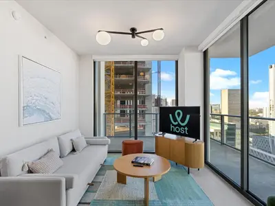 a living room with a couch and a tv at Condo Steps from Bayfront & the Kaseya Center in Miami