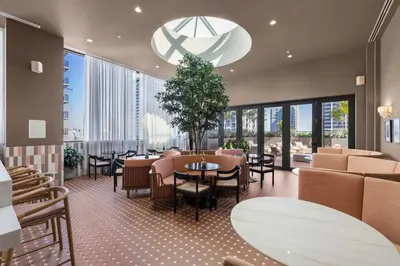 a restaurant with tables and chairs and large windows at Condo Steps from Bayfront & the Kaseya Center in Miami