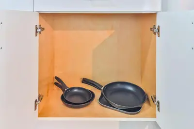 two frying pans sitting inside of a cabinet at Student Villa House STR-2000 in Hollywood