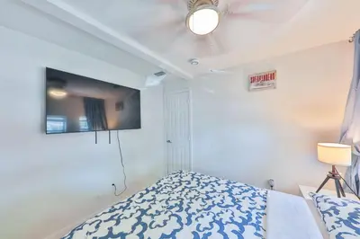 a bedroom with a bed and a tv on the wall at Student Villa House STR-2000 in Hollywood