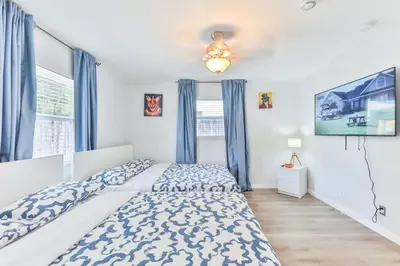 a bedroom with a large bed and blue curtains at Fantastic Family Nest for Joy STR-2310#1 in Fort Lauderdale