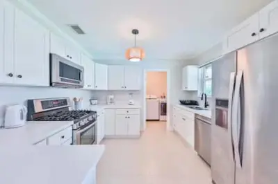 a large white kitchen with white cabinets and appliances at Cruise Family house STR-1761 in Fort Lauderdale