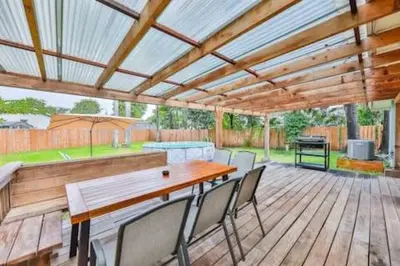 a patio with a wooden table and chairs on a deck at Cruise Family house STR-1761 in Fort Lauderdale
