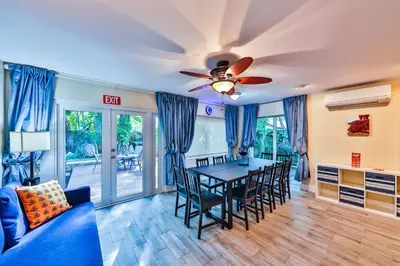 a dining room with a table and chairs and a ceiling fan at Garden botanical Villa with jacuzzi in Hollywood