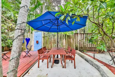 a table and chairs with a blue umbrella on a deck at Garden botanical Villa with jacuzzi in Hollywood