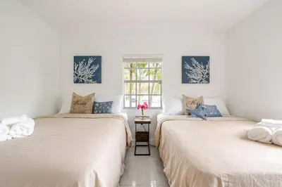 two beds in a room with white walls and a window at Sunset Villa- 3 Bedroom 2 Bathroom -6 Beds in Miami