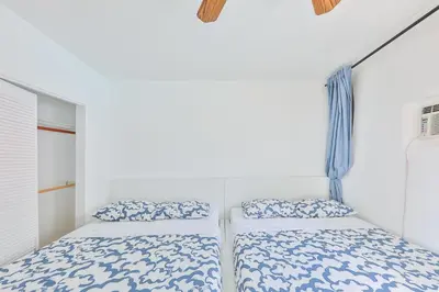 two beds in a bedroom with white walls at Family Casa Tranquila de 4 dormitorios in Hollywood