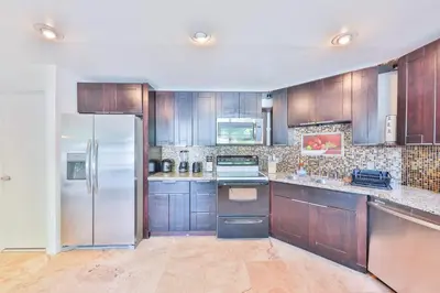 a kitchen with wooden cabinets and a refrigerator at Family Casa Tranquila de 4 dormitorios in Hollywood