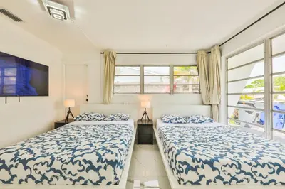 two beds in a room with two windows at Classy Family Stylish Swimming Joy in Hollywood