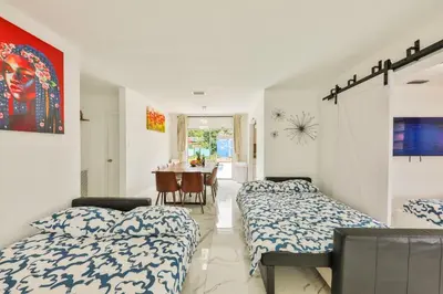 a bedroom with two beds and a dining room at Classy Family Stylish Swimming Joy in Hollywood
