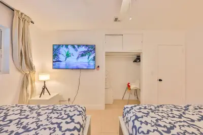 a bedroom with two beds and a tv on the wall at Friday Family Feels Only in Hollywood