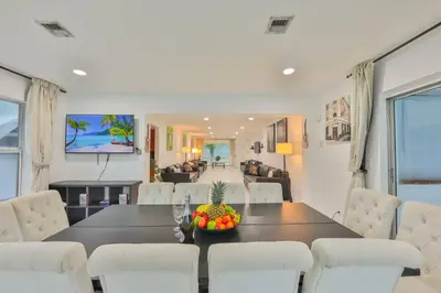 a dining room with a table and white chairs at Friday Family Feels Only in Hollywood