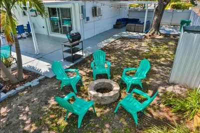 a group of green lawn chairs and a fire pit at Up and down - flat Are boring villa in North Miami Beach