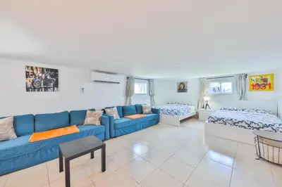 a living room with a blue couch and two beds at Up and down - flat Are boring villa in North Miami Beach