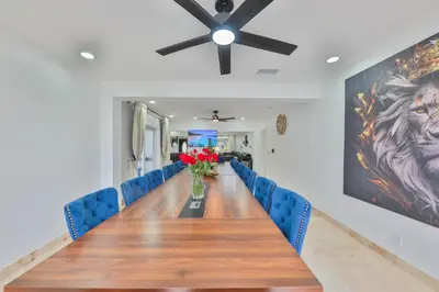 a long table with blue chairs and a ceiling fan at Marble Villa Prime Location in Hollywood
