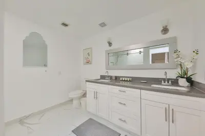 a white bathroom with a sink and a mirror at Haunted corner of Aventura Villa in Miami