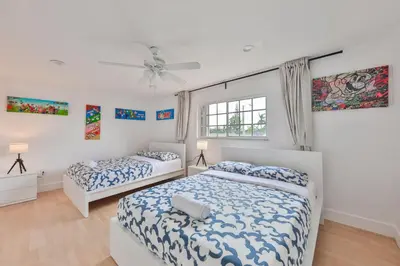 a bedroom with two beds and a ceiling fan at Haunted corner of Aventura Villa in Miami