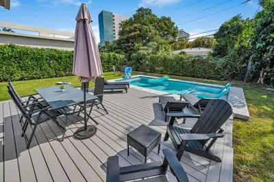 a deck with a table and chairs and an umbrella at The Design District Pool House in Miami