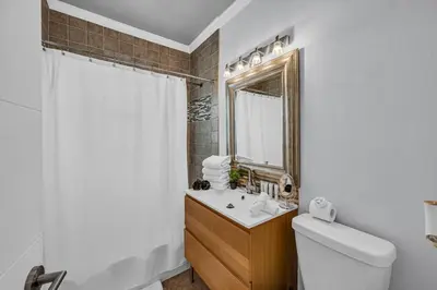 a bathroom with a toilet and a sink and a mirror at Blue Heaven Poolside Retreat Brickell Sleeps 13 in Miami