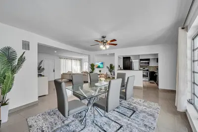 a dining room and living room with a glass table and chairs at The Blue Heaven Private Pool Hideaway Sleeps 11 in Golden Glades