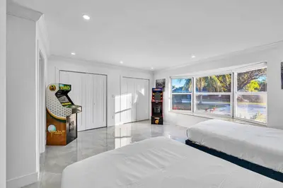 a white bedroom with two beds and a video game at Casa Sol in Richmond Heights
