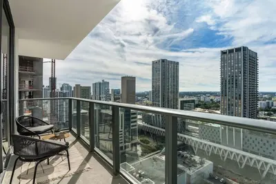 a balcony with a chair and a view of a city at Crosby Miami WTC 2BR 2BA High Floor Corner #3101 in Miami