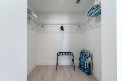 a room with a chair in a room with white walls at Coastal 2BR-2BA Oasis Beach Pool Parking EV Estation in Hallandale Beach