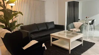 a living room with a black couch and a coffee table at Villa la Morada - Live stress-free in fully furnished, all-inclusive corporate housing! in Miami