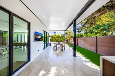 a dining room with a table and large glass windows at Up to 10 Guests! Design District Villa in Miami