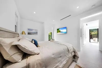 a bedroom with a large bed in a white room at Up to 10 Guests! Design District Villa in Miami
