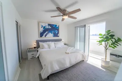 a white bedroom with a bed and a ceiling fan at Penthouse 1BR Miami Beach, amazing Ocean and Skyline views in Miami Beach