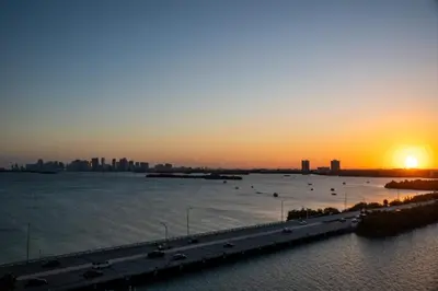 a sunset over a highway next to a body of water at Penthouse 1BR Miami Beach, amazing Ocean and Skyline views in Miami Beach