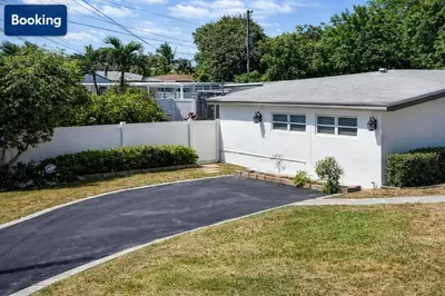 a house with a white fence and a driveway at Comfort Apartment Miramar in Miramar