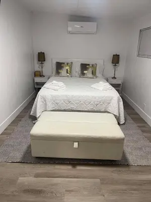 a bedroom with a large bed with two tables at Comfort Apartment Miramar in Miramar