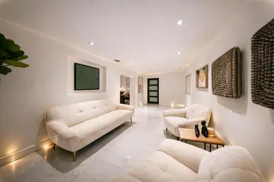 a living room with two couches and a tv at The Rose By Brikell in Miami