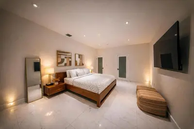 a large bedroom with a bed and a tv at The Rose By Brikell in Miami