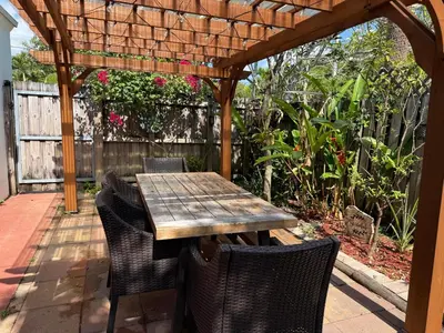 a wooden table and chairs under a wooden pergola at Coconut Villa in Hollywood