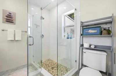 a bathroom with a glass shower and a toilet at Coconut Villa in Hollywood