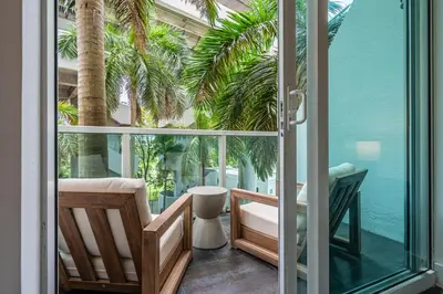 a room with a sliding glass door with palm trees outside at Urban Oasis 2BR Loft Residence in Brickell in Miami