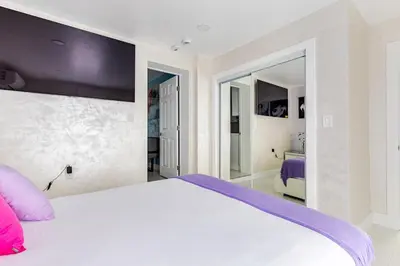 a bedroom with a large white bed with pink pillows at Villa Shallat in Miami
