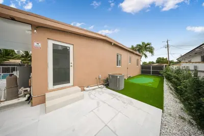 a backyard of a house with a green lawn at Villa Shallat in Miami