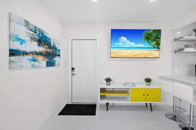 a white room with a yellow dresser and a beach at Walkable 1BR Apt near Las Olas - Fast WiFi & AC in Fort Lauderdale